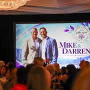 Audience watching a screen that shows Darren and Mike at the Dream Team Gather and Grow 2026 in Vancouver